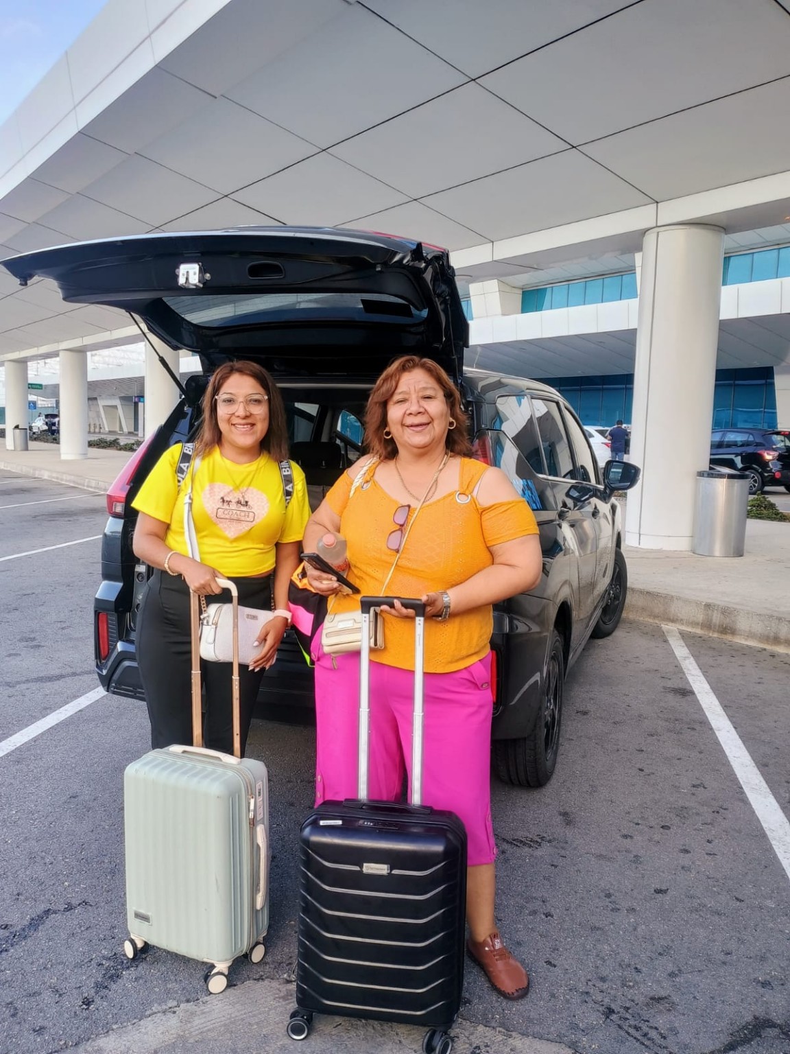 Viajeras con sus maletas junto a su unidad de traslado